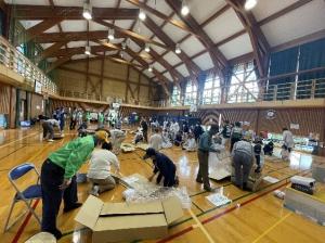 協力して段ボールベッドを組み立てる訓練参加者