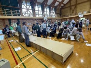 協力して段ボールベッドを組み立てる訓練参加者