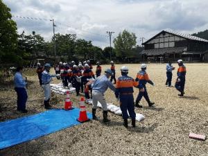 ブルーシートを水に見立てて土のうを積む訓練